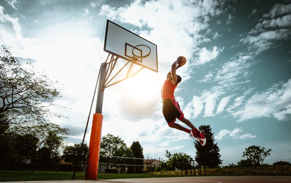 Street basketball player making a powerful slam dunk on the court - HQZ Street basketball player making a powerful slam dunk on the court